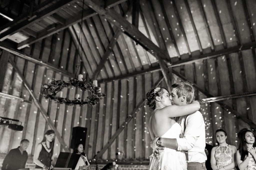 Wedding DJ and live entertainment provider at Lillibrooke Manor luxury Berkshire barn wedding venue - couple embrace whilst band play live