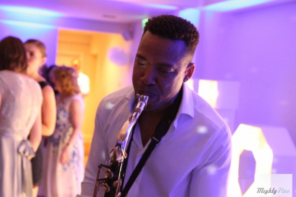 Saxophonist performs to dancing Wedding guests by large light up letters