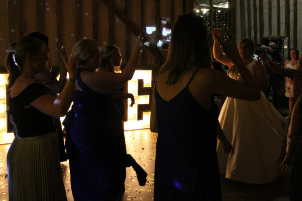 Wedding DJ at Lillibrooke Manor barn wedding venue in Berkshire - bride with bridesmaids and LOVE light up letters
