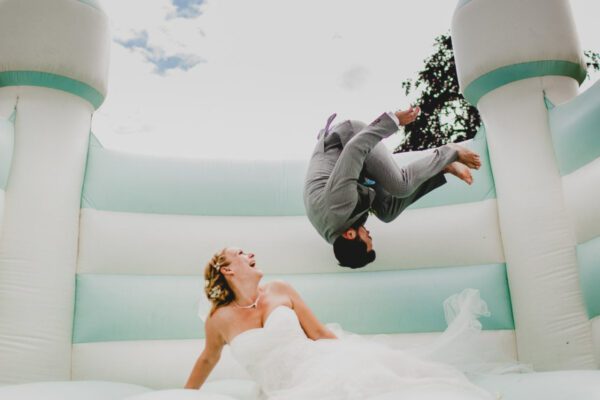 Wedding DJ at Stoke Place indoor and outdoor wedding venue in Buckinghamshire - bride and groom on bouncy castle