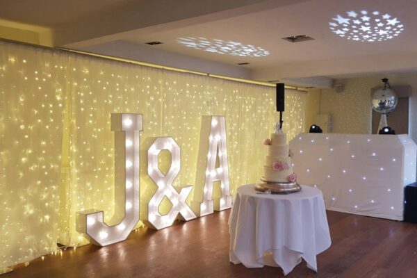 Wedding DJ at Stoke Place wedding venue in Buckinghamshire - DJ booth, light up letters and wedding cake table