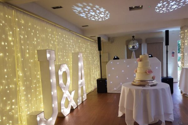 Wedding DJ at Stoke Place wedding venue in Buckinghamshire - LED light up letters alongside DJ booth