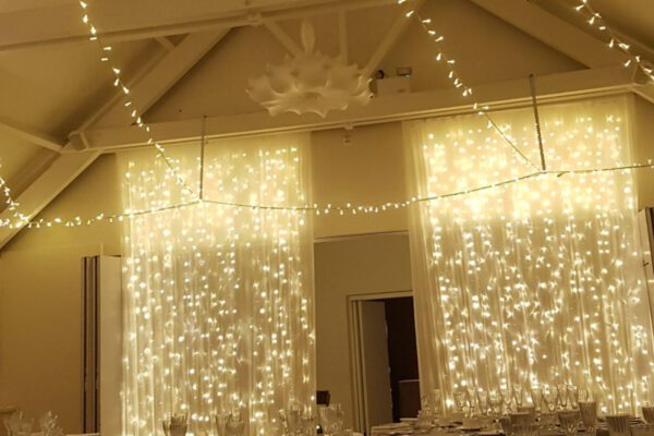 Wedding DJ at Stoke Place wedding venue in Buckinghamshire - fairy light curtains in barn
