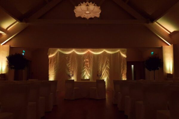 Wedding DJ at Stoke Place wedding venue in Buckinghamshire - warm lighting in barn space