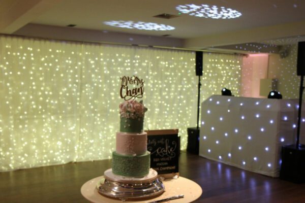 Wedding DJ at Stoke Place wedding venue in Buckinghamshire - cake table and DJ booth setup