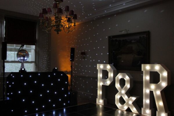 Wedding DJ at Cliveden House, Berkshire - large LED light up letters and DJ setup with mirror ball