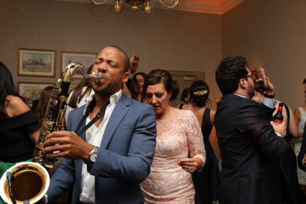 Wedding DJ at Cliveden House, Berkshire - sax player with DJ playing among the guests