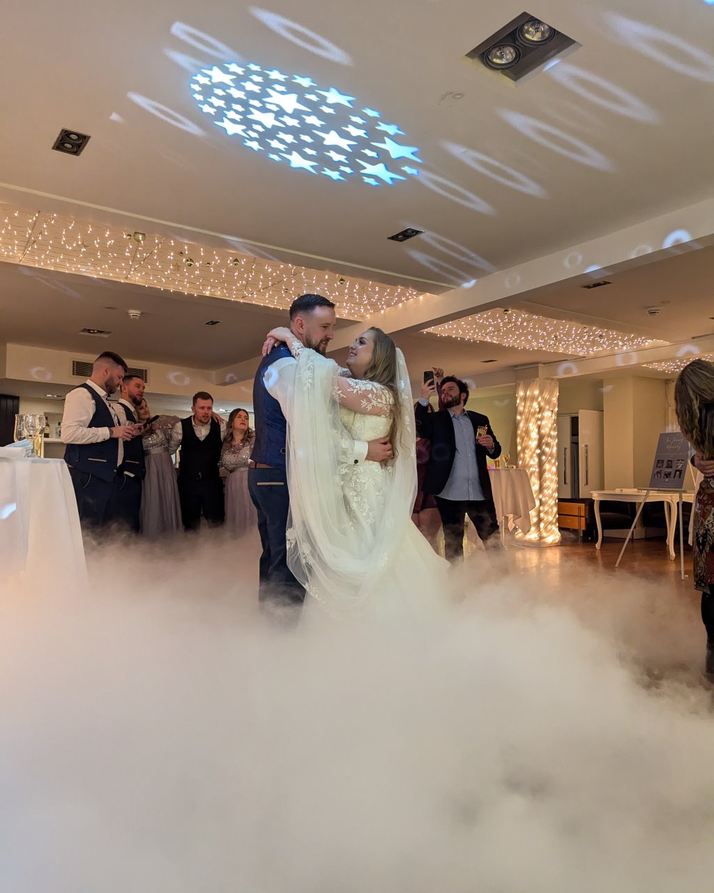 Bridal couple doing their first dance at Stoke Place in Buckinghamshire, UK with a Dancing on the Clouds dry ice effect swirling around their feet.