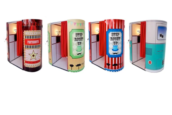 Four colourful photo booths with red curtains are lined up side by side, each unique booth decorated with playful designs and signage inviting people to step inside for fun photo booth memories.